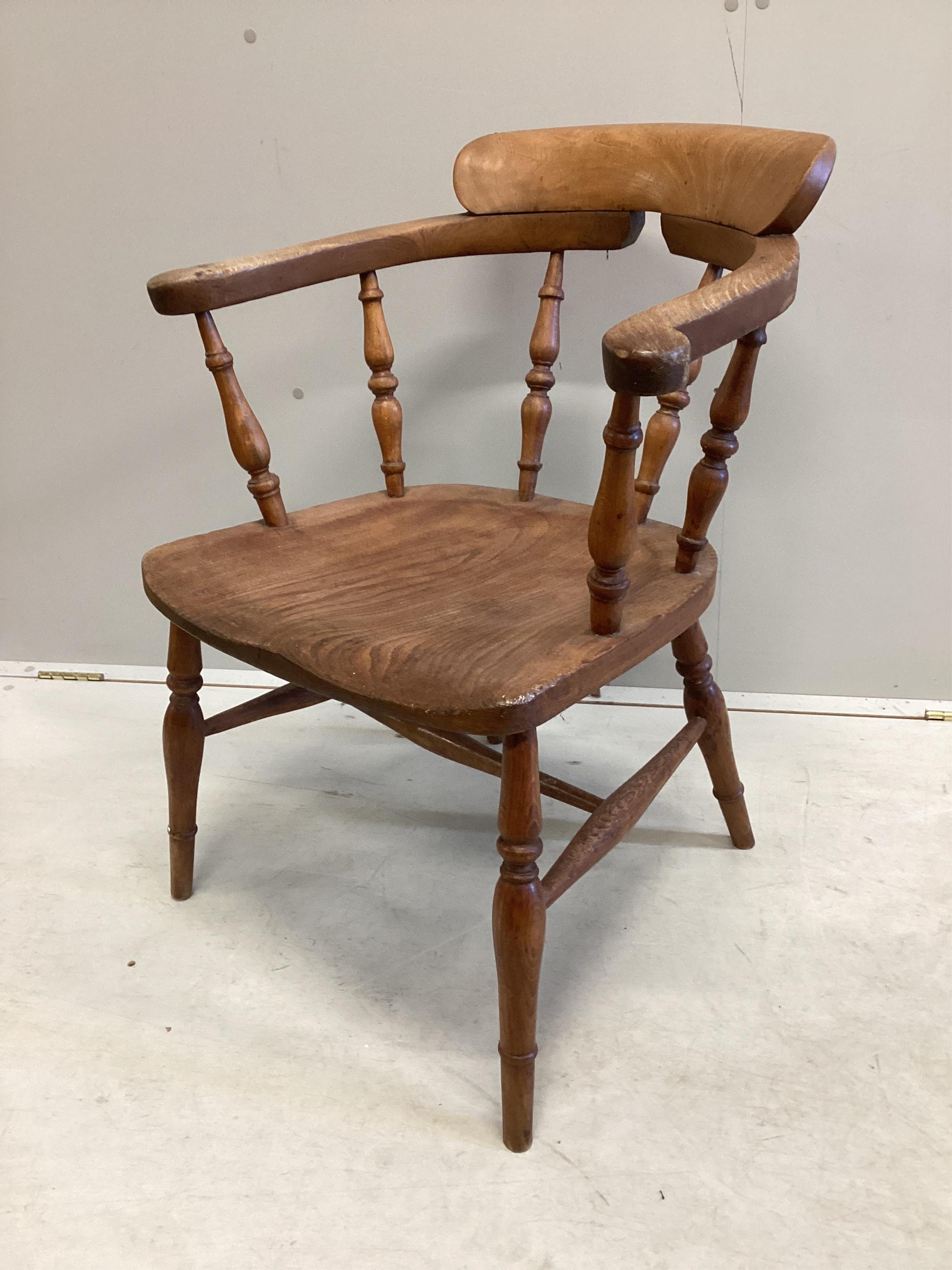 A Victorian elm and beech smoker's bow elbow chair on slender turned baluster legs with H stretcher, width 62cm, depth 45cm, height 78cm. Condition - good, timber slightly faded.